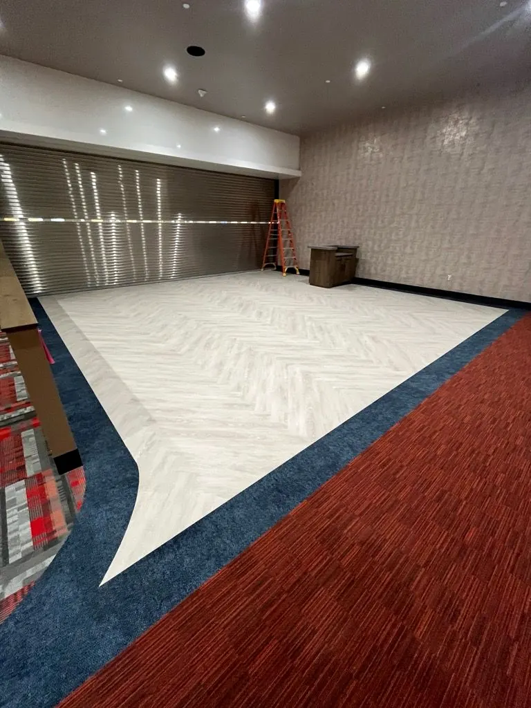 Red and blue carpet tile with a white vinyl inlay