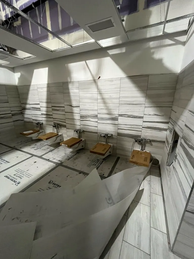 Ceramic tile being installed in a commercial restroom